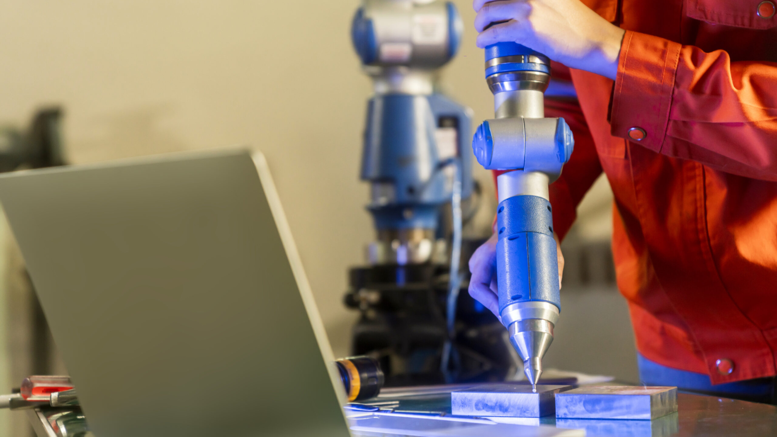 asian female engineer specialist with Measuring machine with a manipulator arm.Three-dimensional coordinate measurement. Check sizes. 3D check of the sizes of parts. CMM after machining process