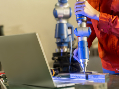 asian female engineer specialist with Measuring machine with a manipulator arm.Three-dimensional coordinate measurement. Check sizes. 3D check of the sizes of parts. CMM after machining process